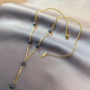Elegant gold-plated stainless steel Y-shaped necklace on a soft purple silk backdrop