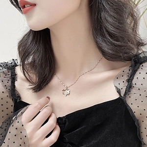 Gold maple leaf pendant necklace worn by a model with a black lace polka dot top