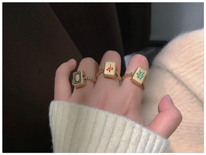 Creatieve mahjong-ringen met goudkleurige kralenbanden gedragen voor Chinees Nieuwjaar