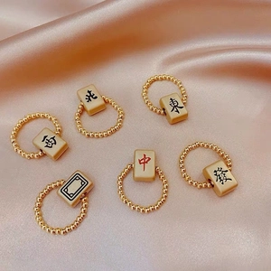 Mahjong kralenringen met gouden accenten en Chinese karakters op zijden achtergrond