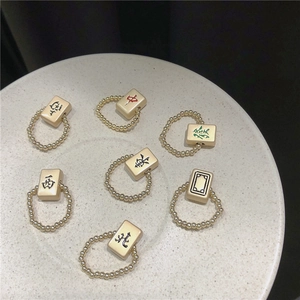 Gedetailleerd bovenaanzicht van zeven Mahjong-ringen met elastische gouden kralenbanden