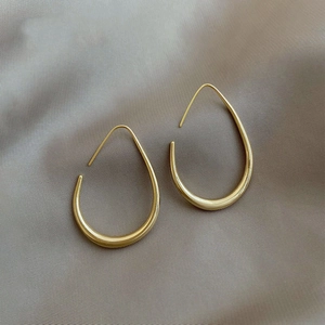 Modieuze gouden eivormige druppeloorbellen met minimalistische gladde metalen afwerking