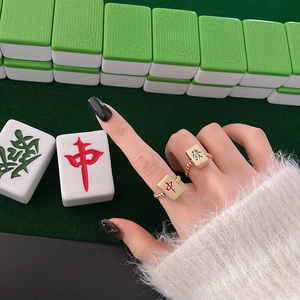 Detail van gouden kralenringen met Chinese mahjong-symbolen in het rood en groen