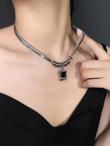 Primer plano de collar doble de acero de titanio con colgante rectangular punk negro