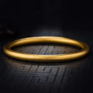 Makroaufnahme eines mattgoldenen Armreifs mit elegantem Finish und schlichtem Design