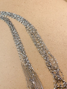 Détail d'un collier à plusieurs rangs en argent avec fermoir mousqueton et extension