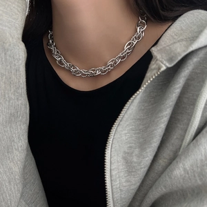 Close-up of a chunky silver braided chain necklace worn with casual streetwear style