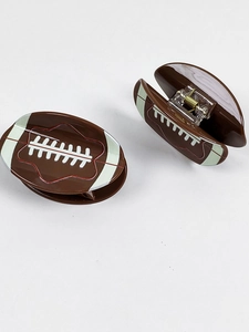 Brown rugby-shaped hair claw clip with white stitching details on a white background