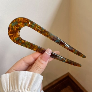 Tortoiseshell acetate U-shaped hair pin with blue speckles and gold branding
