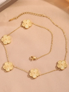 Vue détaillée du collier trèfle doré avec pendentifs fleurs texturés et fermoir poinçonné S925