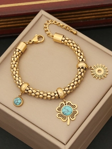 Détails du bracelet tressé doré avec pendentifs de fleurs turquoises et motifs de soleil