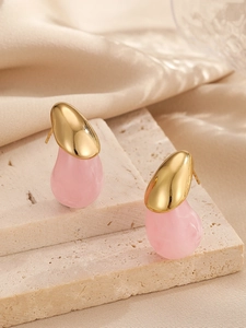 Détail de boucles d'oreilles en résine rose en forme de larme avec finition dorée