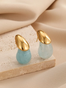 Vue détaillée de boucles d'oreilles goutte en métal doré et texture marbrée bleu clair