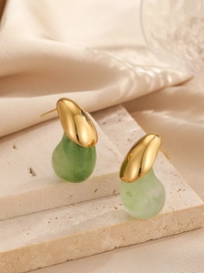Détail de boucles d'oreilles dorées en forme de goutte avec résine vert clair