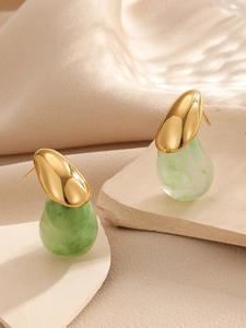 Détail des boucles d'oreilles en métal doré poli et résine marbrée verte en goutte