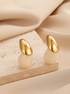 Gros plan détaillé des boucles d'oreilles goutte crème sur pierre et soie