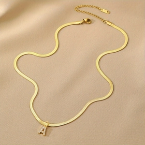 Gold snake chain necklace with sparkling crystal encrusted letter A pendant on silk