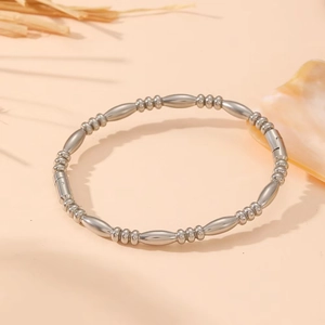 Polished silver stainless steel beaded bangle featuring oval links and a secure clasp closure