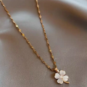 Collier avec pendentif trèfle doré, pétales blancs nacrés et centre en cristal