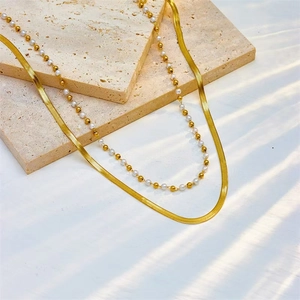 Double-layered gold titanium necklace with flat snake chain and white pearl strand