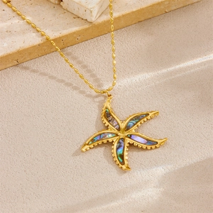 Gold starfish pendant necklace with rainbow shell inlay and bead chain on stone base
