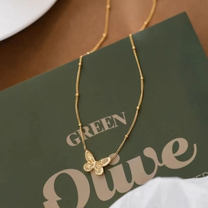 Collar con colgante de mariposa dorada y textura de ala sobre una elegante cadena de cuentas