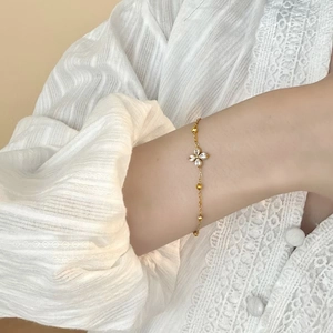 Elegante gouden klaver armband met zirkonia stenen gedragen om een dames pols