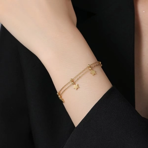 Bracelet double rang avec breloques étoiles dorées et chaînes à billes fines