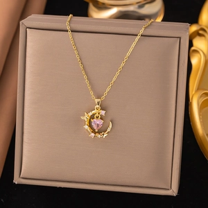 Elegante goldene Halskette mit rosa Herzstein und Mondsichel-Anhänger auf Schmuckbox