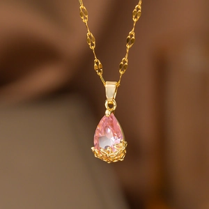 Collier avec pendentif goutte en zircon rose et serti floral doré sur de la soie