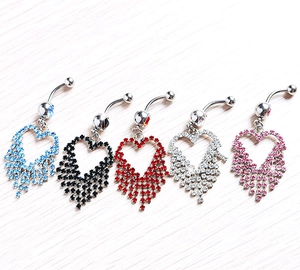 Close-up of five heart tassel belly rings with colorful rhinestones on wood background