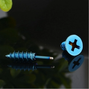 Detail van de blauwe metalen oorstekers met een industrieel schroefontwerp