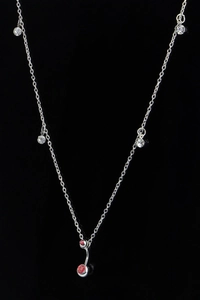 Detailweergave van zilveren lichaamsketting met heldere kristallen en rode navelpiercing
