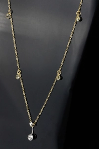 Detail van een delicate gouden buikketting met fonkelende ronde kristallen hangers