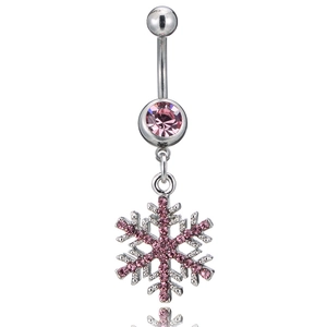 Détail macro du piercing de nombril flocon avec strass roses et barre courbée polie