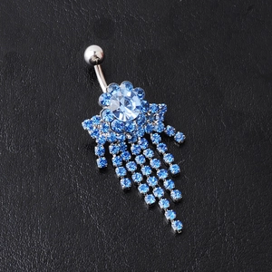 Detail of silver floral belly ring with blue crystals and multi-row fringe tassels