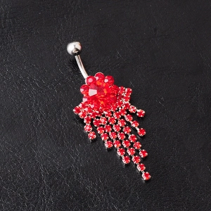Detail of flower belly ring with red crystals and tassel chains on leather