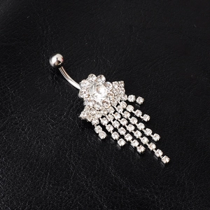 Close-up of silver tassel belly button ring with rhinestones on black leather