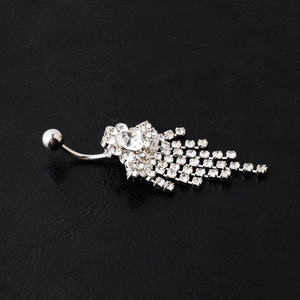 Detailed view of silver belly ring with sparkling rhinestone tassels on black leather background