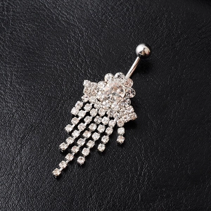 Macro detail of silver flower belly ring featuring hanging crystal rhinestone tassels