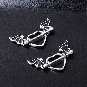 Pair of stainless steel bat wing heart nipple shields with black enamel on leather background