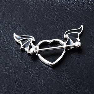 Gothic heart barbell nipple ring with black bat wings on textured leather backdrop
