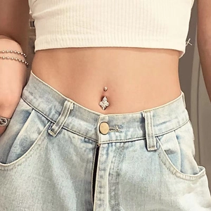 Macro shot of a floral navel ring with marquise-cut zircon worn by a model on the belly