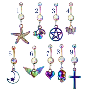 Dettaglio di nove piercing all'ombelico iridescenti con ciondoli a stella, cuore e farfalla