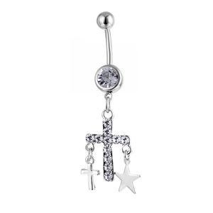 Macro detail of silver navel ring featuring dangling cross and star charms with zircons