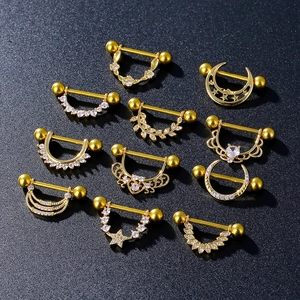 Détail d'un ensemble de piercings de téton dorés avec zircons, motifs étoile et lune