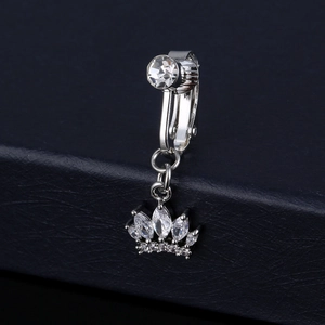 Dettaglio macro del finto piercing all'ombelico a corona in argento con zirconi