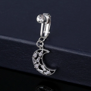 Macro shot of silver crescent moon clip-on navel ring with baguette and round zircons