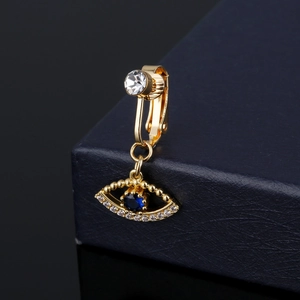 Dettaglio del finto piercing all'ombelico dorato con pendente occhio greco e zirconi