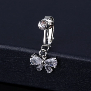Detail of silver bow belly ring with clear cubic zirconia stones on black leather